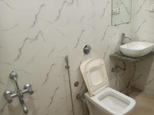 a bathroom with a white toilet and a sink at Hotel Gungun Jawai, Sumerpur in Sheoganj +73 photos