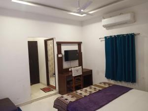 a bedroom with a bed and a mirror and a television at Hotel Gungun Jawai, Sumerpur in Sheoganj