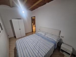 a bedroom with a bed and a refrigerator in it at Mas De La Salut in Sant Jaume Sas Oliveras