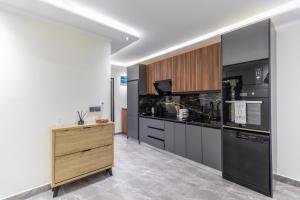 a kitchen with black appliances and wooden cabinets at FLORIA - Sky Suites in Accra