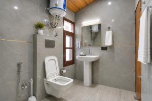 a bathroom with a toilet and a sink and a mirror at The Elena Dogri Homes, A Comfortable & Luxury Stay - Best Selling Cottage 2025-26 in Shimla +24 photos