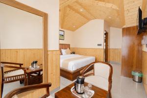 a bedroom with a bed and a table and a chair at The Elena Dogri Homes, A Comfortable & Luxury Stay - Best Selling Cottage 2025-26 in Shimla