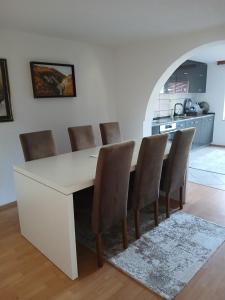 a white dining room table with chairs and a kitchen at Kuća za odmor Tarik in Cazin