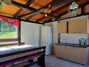 a kitchen with a counter and a refrigerator and a window at Cabana Bianca in Arieşeni