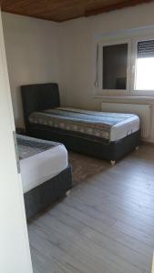 two beds sitting in a room with a window at Kuća za odmor Tarik in Cazin