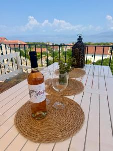 a bottle of wine and a wine glass on a table at Mirca with seaview - charming stonehouse in Mirce