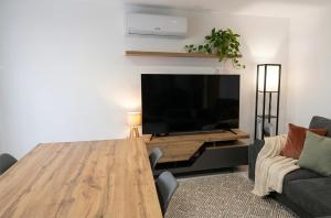 a living room with a wooden table and a flat screen tv at Casa Machado in Cabeceiras de Basto