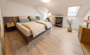 a bedroom with a large bed and wooden floors at BETTSTOD - Ruhige Ferienwohnung für 2 , Bayerischen Wald, Nationalpark Spiegelau, Naturbad in Spiegelau