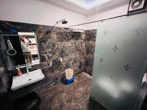 a man taking a picture of a bathroom with a sink at Hotel The Five Star Inn in Muzaffarpur