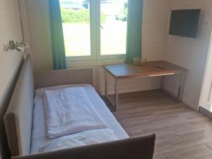 a small room with a bed and a table at domek 3 osoobowy in Augustów
