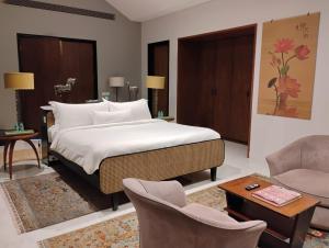 a bedroom with a bed and a couch and chairs at amarzito villa in Dona Paula +11 photos
