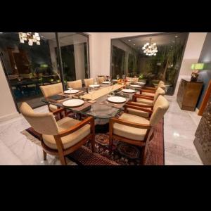 a long dining room with a long table and chairs at amarzito villa in Dona Paula