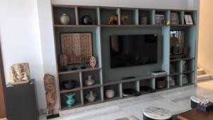 a living room with a tv in atainment center at amarzito villa in Dona Paula