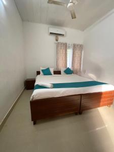 a bedroom with a large bed with blue pillows at villas alleppey in Alleppey