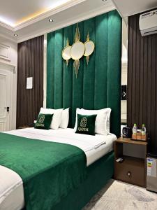 a bedroom with a large bed with a green wall at Qadim Hotel in Samarkand