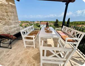a white table and two chairs on a balcony at Mirca with seaview - charming stonehouse in Mirce
