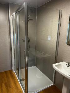 a shower stall in a bathroom with a sink at Chevin End Guest House in Otley +44 photos