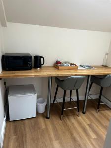 a wooden table with a microwave and two chairs at Chevin End Guest House in Otley