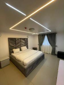 a bedroom with a large bed with lights on the ceiling at Teddy apartment in Lagos