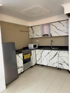 a kitchen with white marble counter tops and appliances at Teddy apartment in Lagos