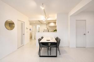 a dining room with a table and black chairs at Miyako Beach Resort in Hirara