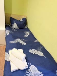 a bed with a blue comforter with towels on it at Moss House in Sevan