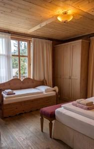 a bedroom with two beds and a wooden ceiling at Guesthouse Hotel Between in Chamoson