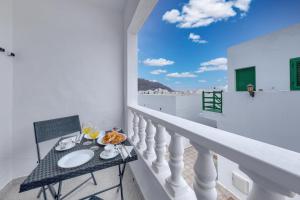 a table on the balcony of a house at Casa Suso y Casa Margarita- Orzola Coastal Retreat by LVH in Órzola