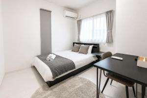 a bedroom with a bed and a desk and a table at Miyako Beach Resort in Hirara