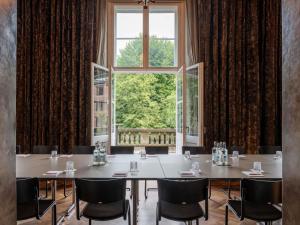ein Besprechungsraum mit einem Tisch und einem großen Fenster in der Unterkunft Das Stue in Berlin