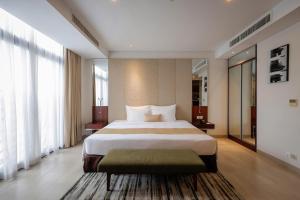a hotel room with a large bed and large windows at SILA Urban Living in Ho Chi Minh City