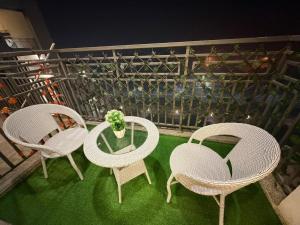 three wicker chairs and a table with a potted plant at M R ComfortHeaven in Greater Noida