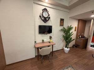 a room with a desk and a clock on the wall at M R ComfortHeaven in Greater Noida