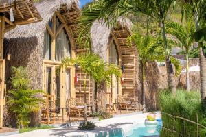 a resort with a swimming pool and palm trees at Mare Eco Bungalows - Kids & Family friendly in Kuta Lombok