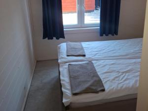 two towels sitting on a bed in a room with a window at domek 3 osoobowy in Augustów