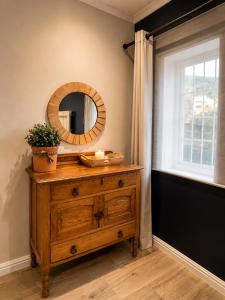 a bathroom with a wooden dresser with a mirror at Stay on Main - Studio Blue in Paarl