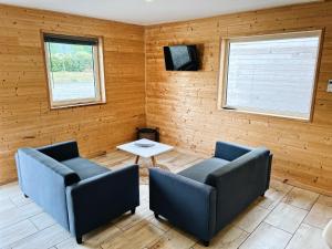 a living room with two couches and a table at Chalet des illes BERMUDE III in Prat-et-Bonrepaux