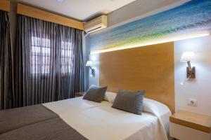 a bedroom with a bed and a window at Ona Las Rosas in Puerto de Santiago +21 photos