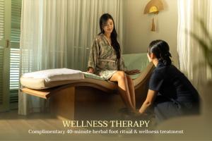 a woman sitting on a bed talking to a girl at Bhaya Soul - Wellness Inclusive Cruise in Ha Long