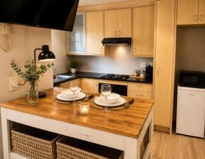 a kitchen with a wooden table with two glasses on it at Stay on Main - Studio Blue in Paarl