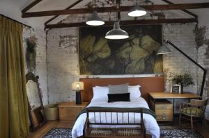 a bedroom with a bed with a painting on the wall at SOUSIE'S RUSTIC STAY in Polokwane