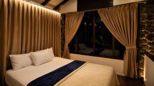 a bedroom with a bed and a window with curtains at The Haven 3BR Private Pool Lembang in Tegalharendong
