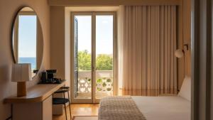 a hotel room with a bed and a desk and a window at Villa Paola in Tropea +49 photos