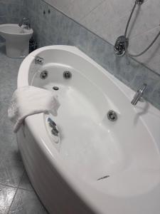 a white bath tub with a hand holding a towel at Peperoncino Home in Pedeguarda +30 photos