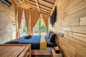 a bedroom with a bed in a wooden wall at Mare Eco Bungalows - Kids & Family friendly in Kuta Lombok