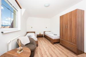 a room with two beds and a chair and a window at Penzion Maja in Martin +3 photos