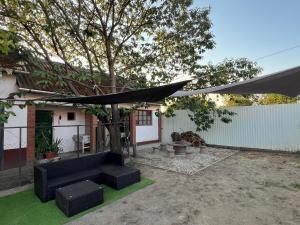 a patio with a black umbrella and a tree at Emese Vendégház in Tiszafüred