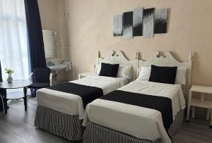 a hotel room with two beds and a sink at Hospedaje Botin in Santander +20 photos