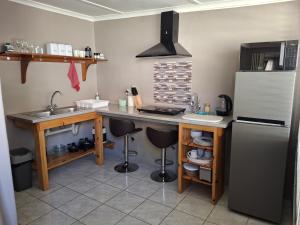 a kitchen with a counter with a sink and a refrigerator at 3de laan Springbok in Springbok