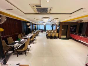 a dining room with tables and chairs in a restaurant at Hotel The Five Star Inn in Muzaffarpur